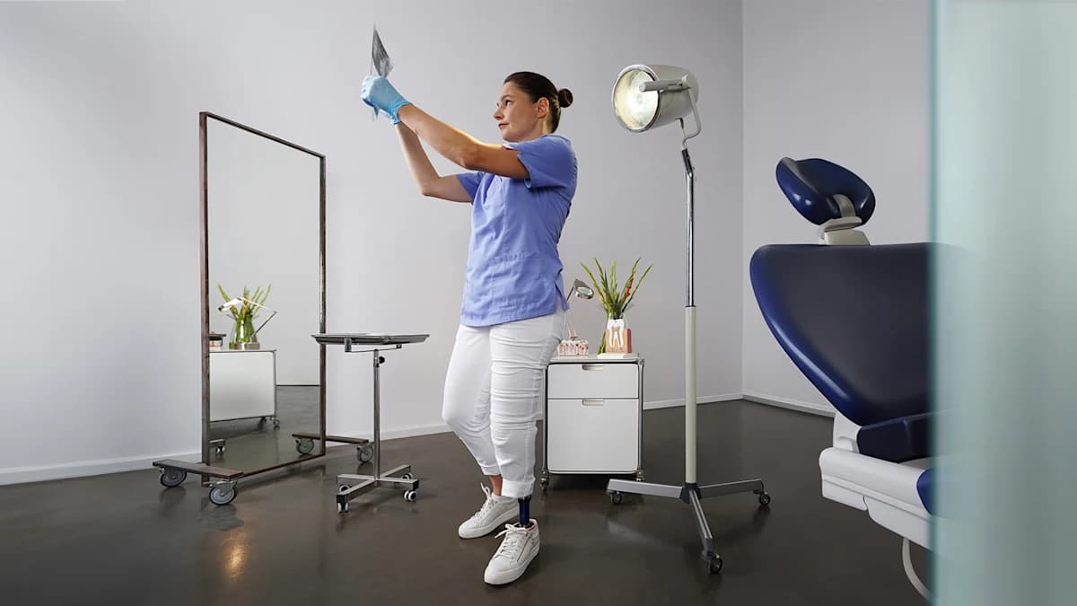 Daniela wearing an Evanto prosthetic foot standing in a dental studio.