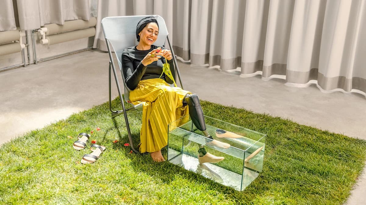 Zainab sitting on a chair resting her Genium X3 and Taleo Adjust in a glass container full of water