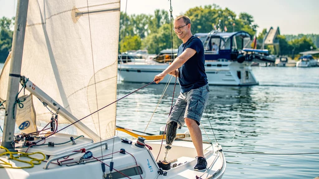 A male user standing on a sailing boat with his Taleo Side Flex foot.