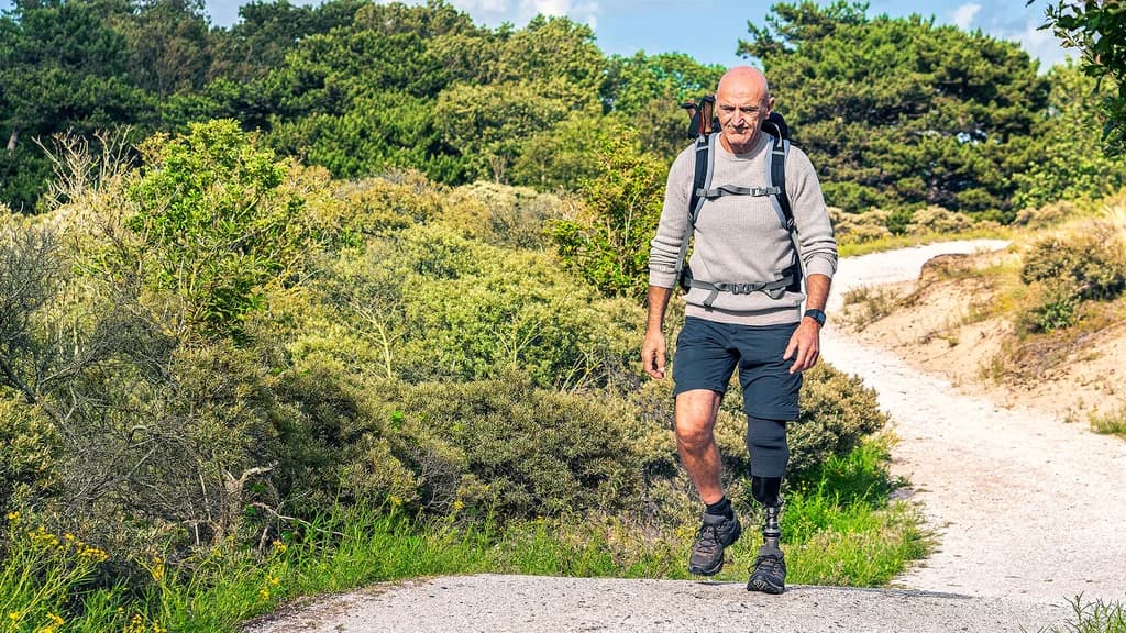 A male user walking in the forest with his Taleo Harmony prosthetic foot.