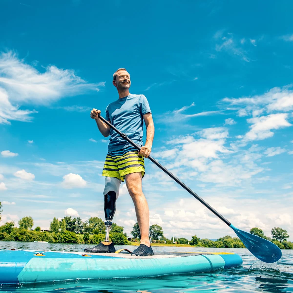 A male user standing on a stand-up paddle board with his Taleo Side Flex carbon foot.