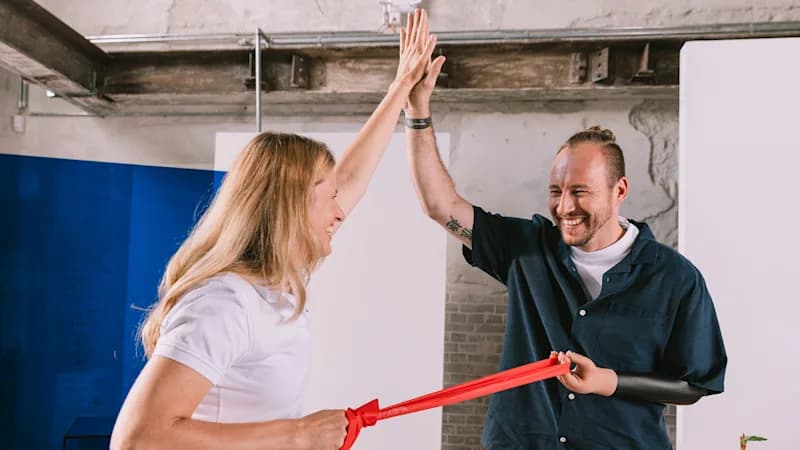 A VariPlus Speed prosthetic hand pulling on a resistance band with their physiotherapist.
