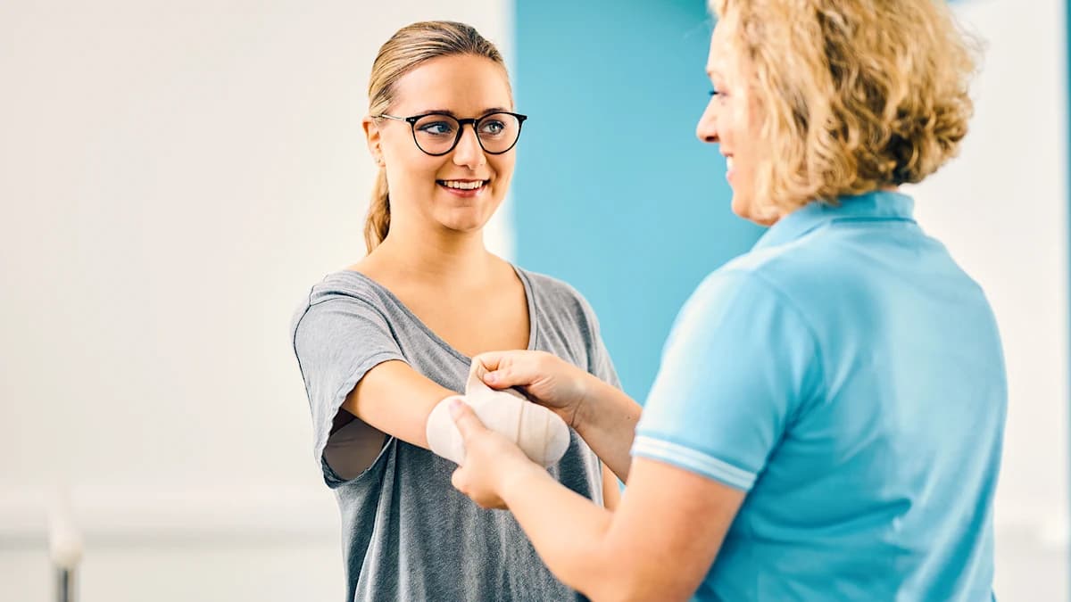 An orthotics and prosthetics professional aids an amputee in wrapping their residual limb