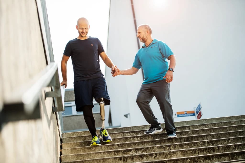 Prosthetic user walking outdoors on uneven terrain