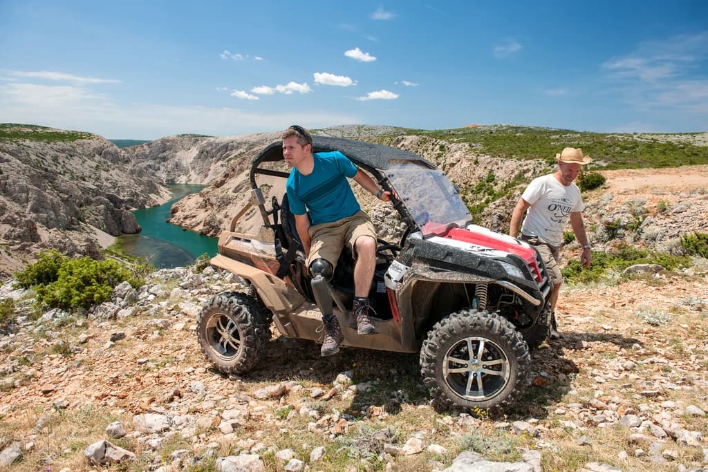 John steps out of an ATV on a rocky terrain with ease using his Genium X3 prosthetic knee.