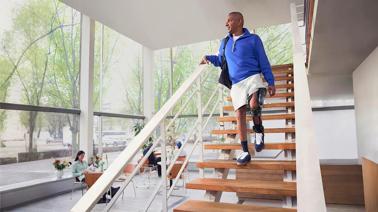 A man walking down stairs wearing a C-Brace.