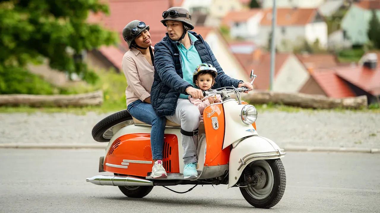 Christoph with his family on a scooter, wearing an Agilium knee orthosis.